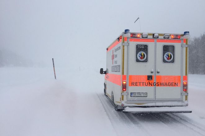 Rettungswagen des Roten Kreuzes auf verschneiter Straße